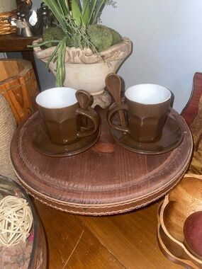 Two brown stoneware espresso cups and saucers with spoons